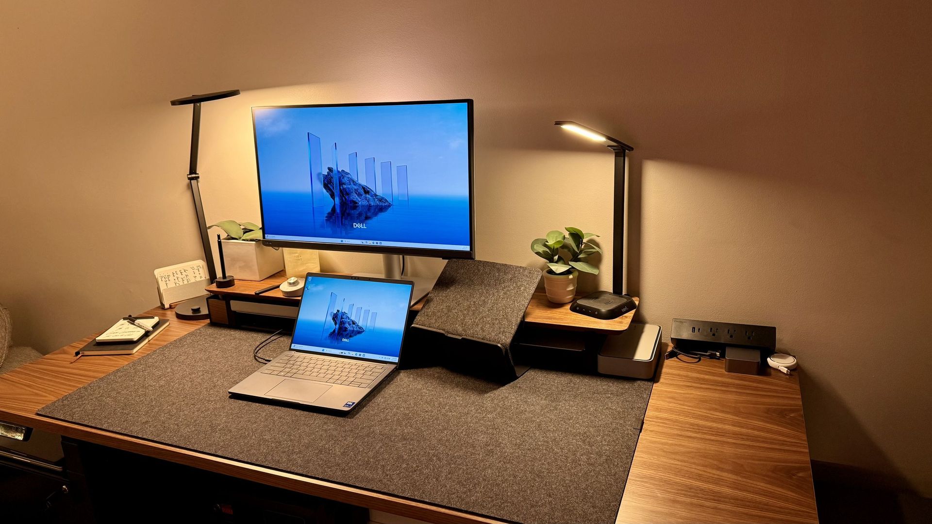 Studio desk with monitor and laptop where client sites get built